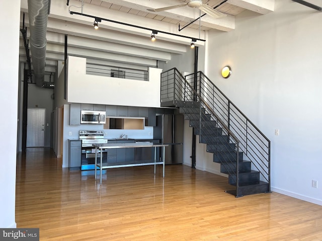 kitchen featuring wood ceiling, stainless steel appliances, beamed ceiling, light wood-type flooring, and sink