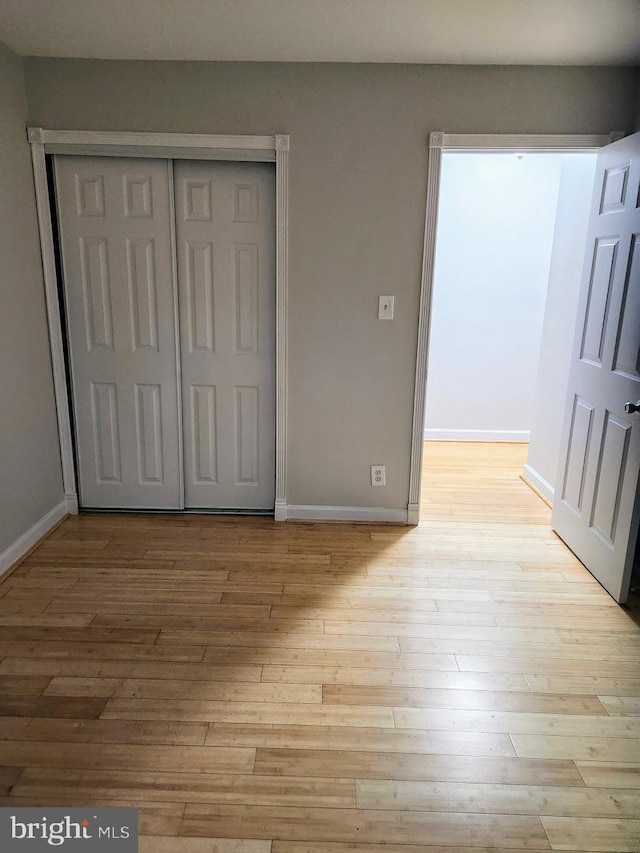 unfurnished bedroom featuring a closet and light hardwood / wood-style flooring