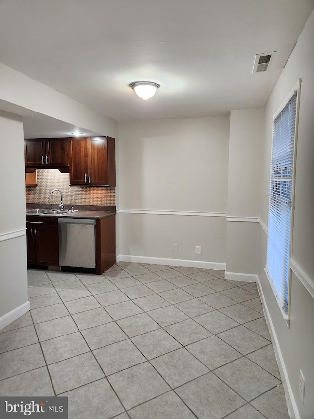 kitchen with sink, backsplash, light tile patterned floors, and dishwasher