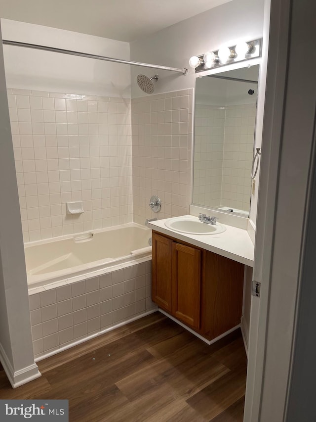 bathroom with tiled shower / bath, wood-type flooring, and vanity