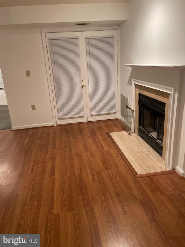 unfurnished living room featuring a premium fireplace and wood-type flooring