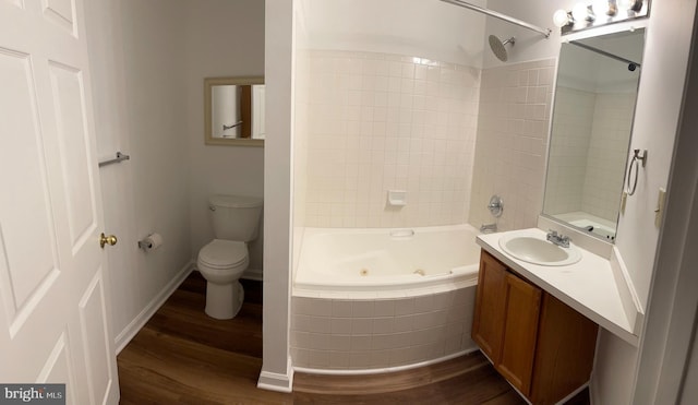 full bathroom with vanity, hardwood / wood-style floors, tiled shower / bath combo, and toilet