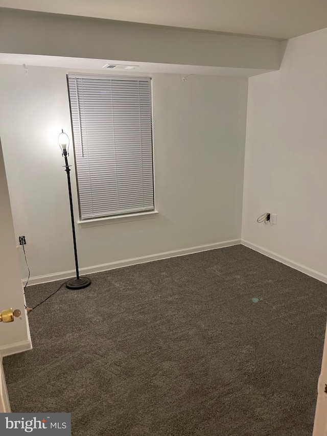 empty room featuring dark carpet