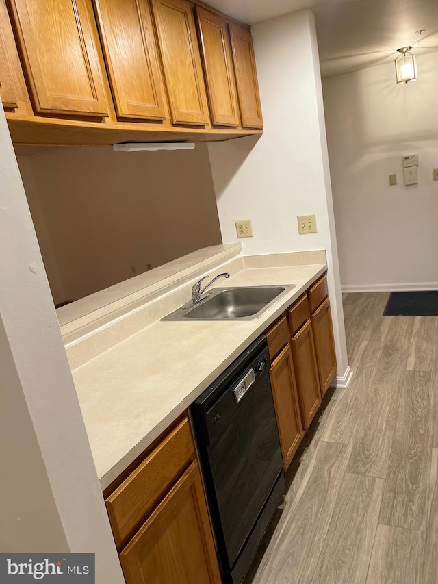 kitchen with dishwasher, sink, and light wood-type flooring