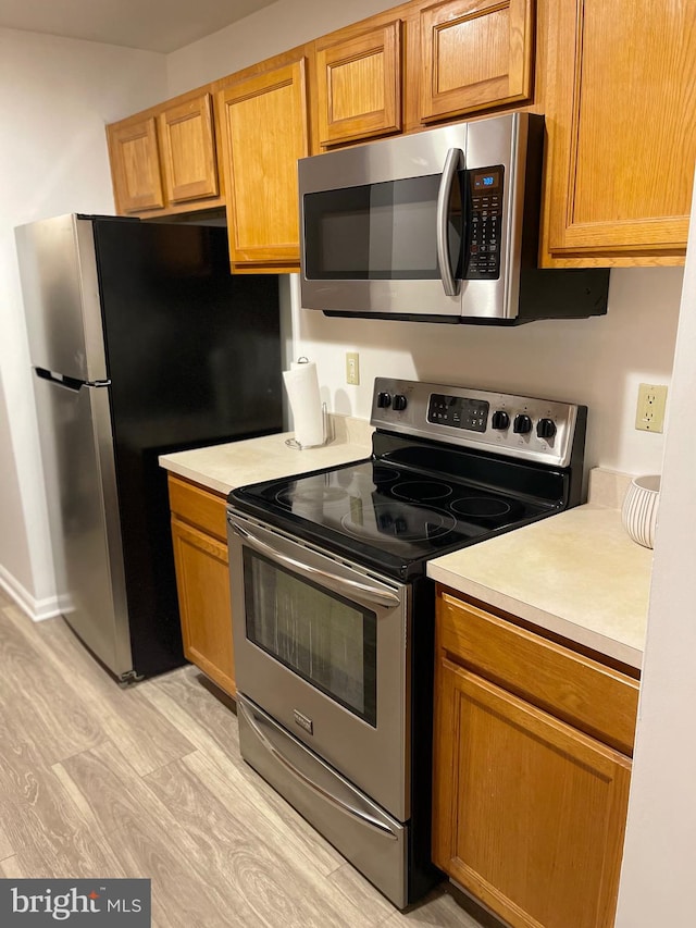 kitchen featuring light hardwood / wood-style floors and appliances with stainless steel finishes