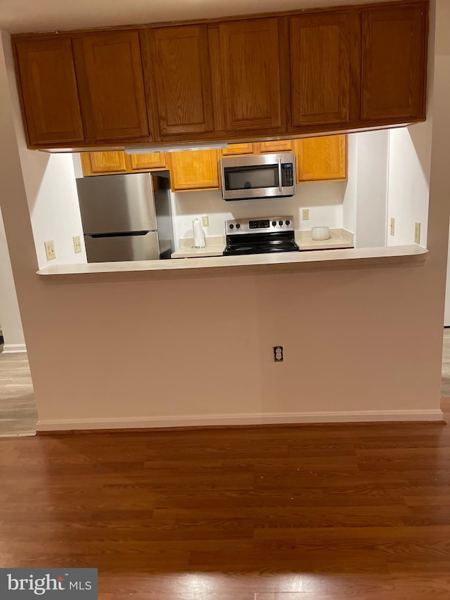 kitchen with dark hardwood / wood-style flooring and stainless steel appliances