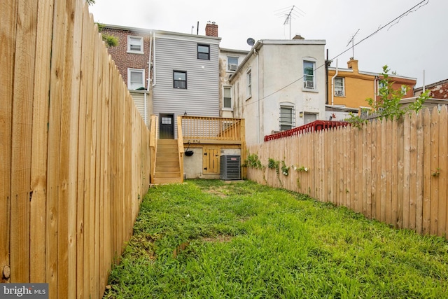 back of house featuring central AC and a yard