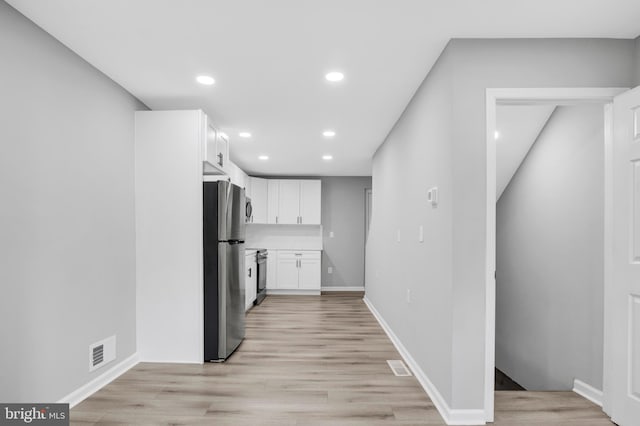 kitchen featuring white cabinetry, appliances with stainless steel finishes, and light wood-type flooring