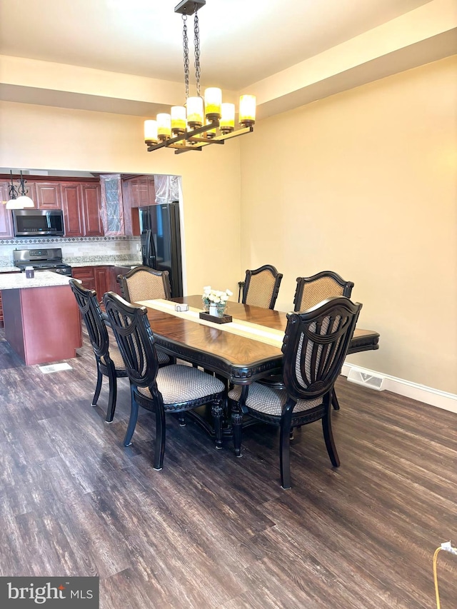 dining space with a notable chandelier and dark hardwood / wood-style floors