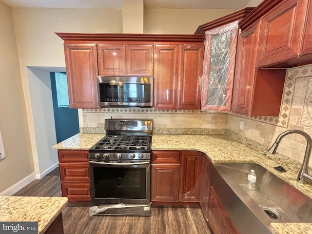 kitchen featuring dark hardwood / wood-style flooring, backsplash, and stainless steel appliances