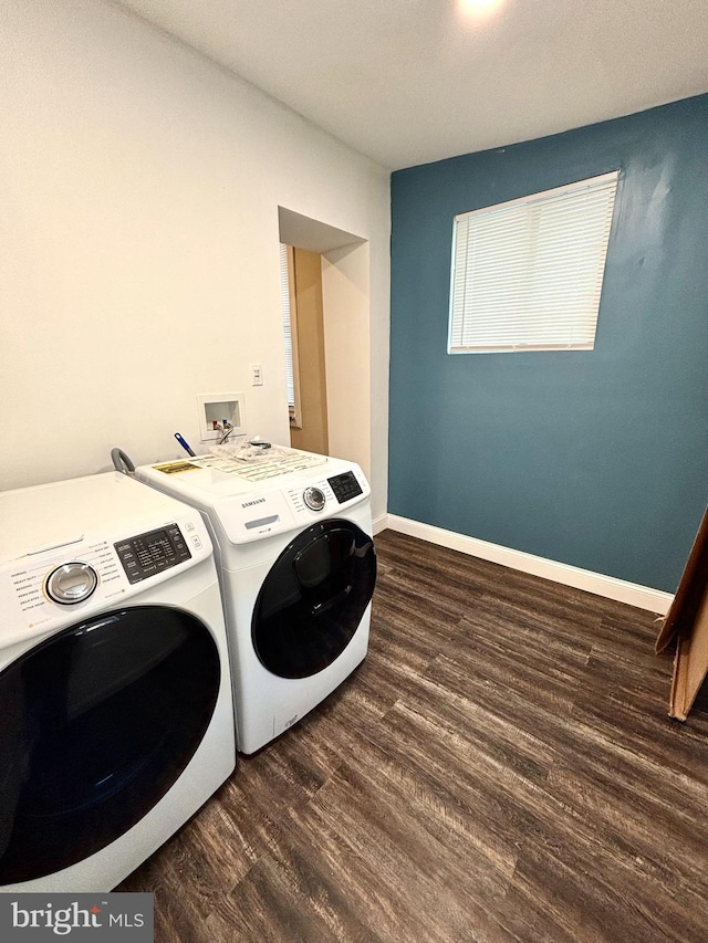 clothes washing area with washer and clothes dryer and hardwood / wood-style flooring