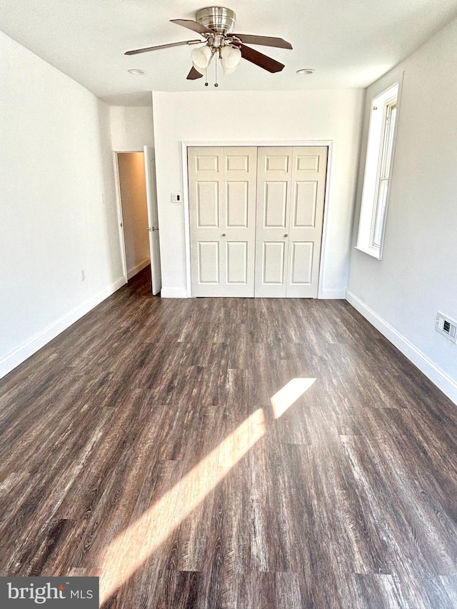 unfurnished bedroom featuring dark hardwood / wood-style floors and ceiling fan