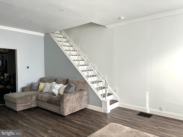 living room with dark wood-type flooring and crown molding