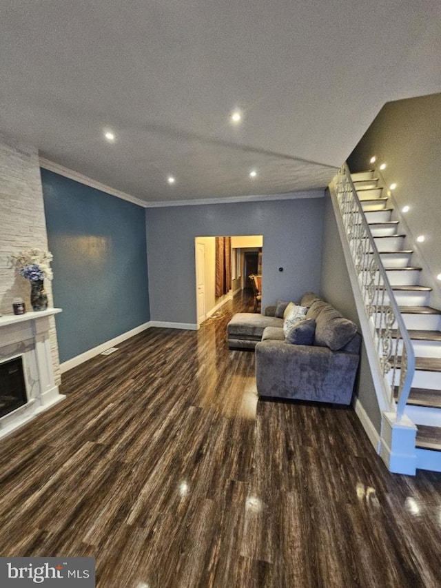 living room with a textured ceiling, wood-type flooring, and crown molding