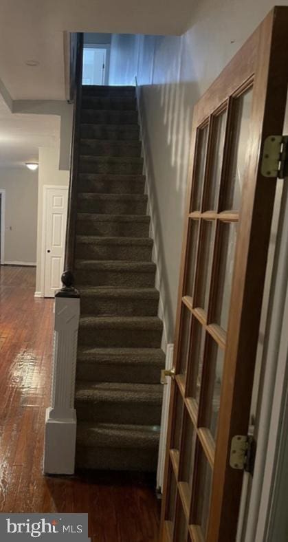 staircase with hardwood / wood-style floors