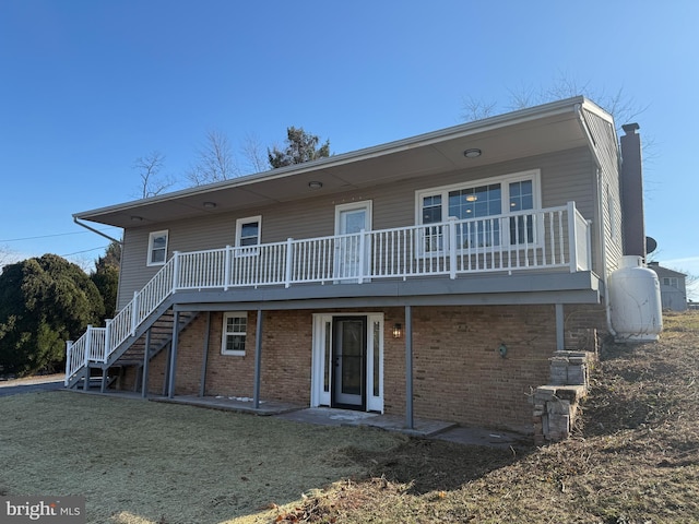 rear view of house with a lawn and a wooden deck