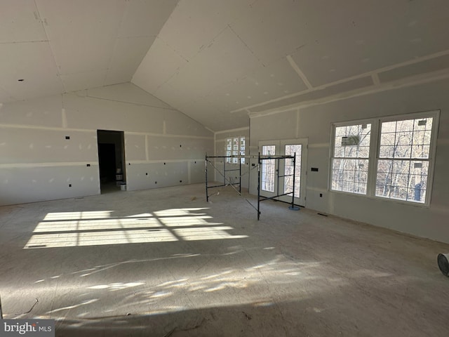 unfurnished living room featuring lofted ceiling