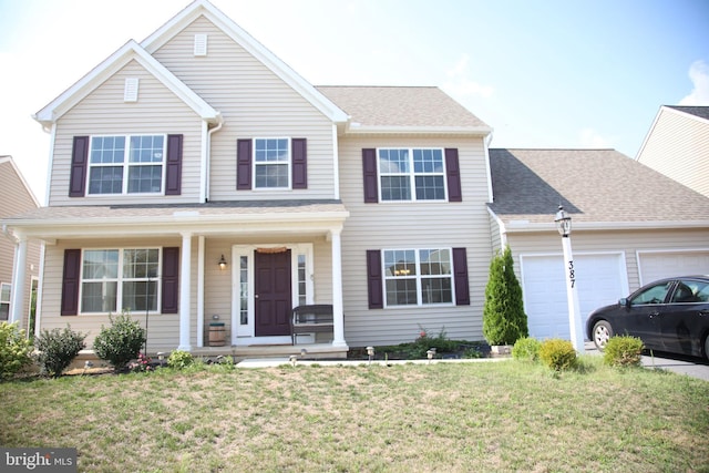 view of front facade with a garage, a front lawn, and a porch