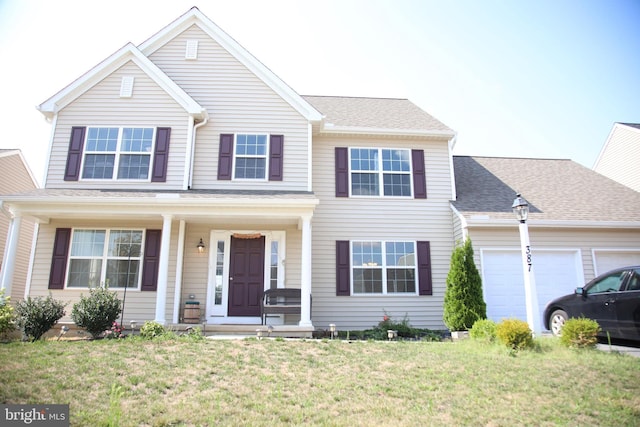 view of front of home with a garage and a front lawn