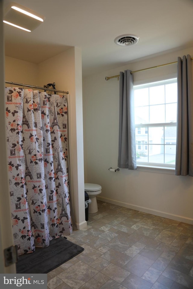 bathroom with walk in shower and toilet