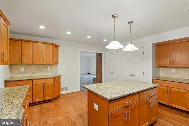 kitchen featuring decorative backsplash, brown cabinetry, recessed lighting, and light wood-style floors