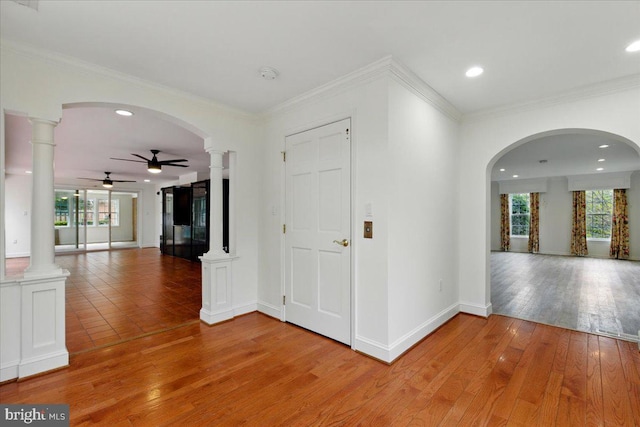 corridor featuring recessed lighting, baseboards, light wood finished floors, and ornate columns