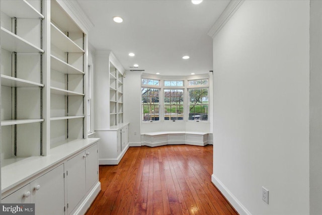 interior space featuring hardwood / wood-style flooring, baseboards, ornamental molding, and recessed lighting