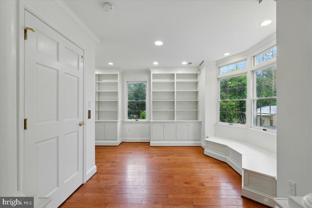 interior space with hardwood / wood-style flooring, recessed lighting, and crown molding