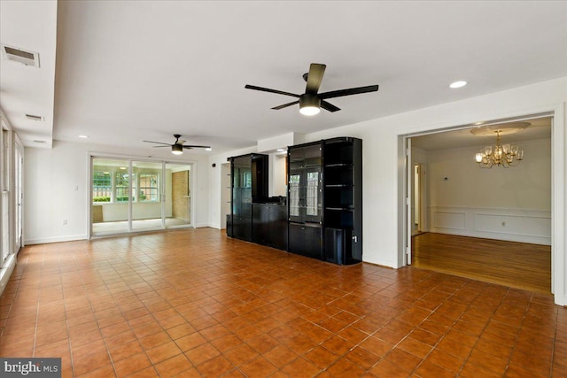 unfurnished living room with ceiling fan with notable chandelier, tile patterned floors, visible vents, and recessed lighting