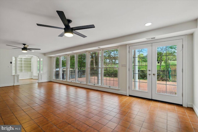 interior space featuring tile patterned floors, a ceiling fan, and a wealth of natural light