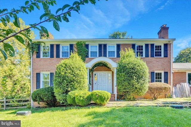 colonial inspired home featuring a front lawn