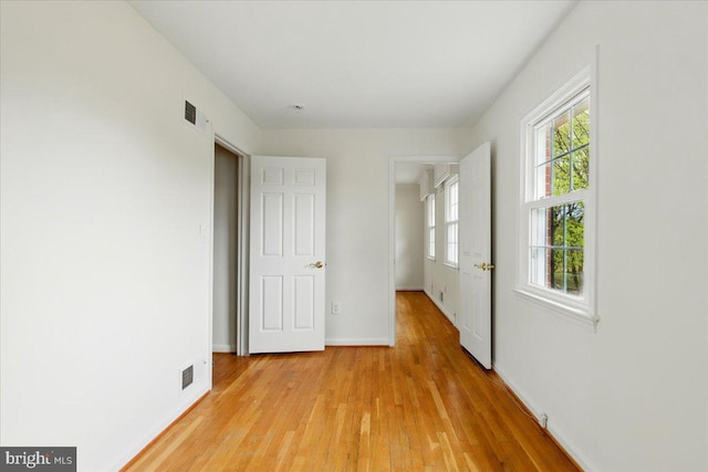 unfurnished bedroom featuring light wood-type flooring, visible vents, and baseboards
