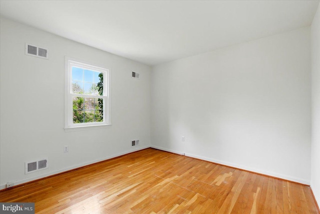 unfurnished room featuring baseboards, visible vents, and light wood-type flooring