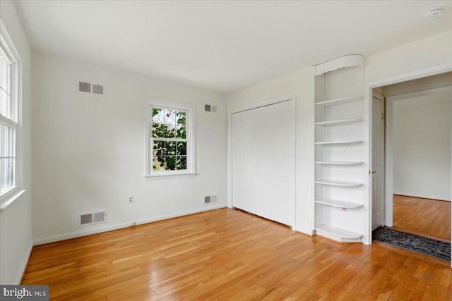 unfurnished bedroom with light wood-style floors and visible vents
