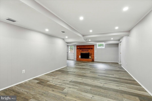 unfurnished living room with recessed lighting, wood finished floors, visible vents, baseboards, and a brick fireplace