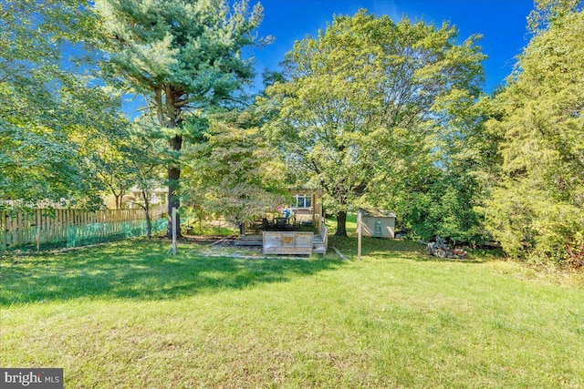 view of yard with fence, an outdoor structure, and a storage shed