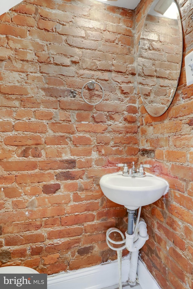 bathroom with brick wall