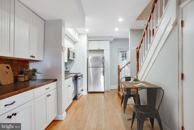 kitchen featuring appliances with stainless steel finishes, light hardwood / wood-style flooring, and white cabinets