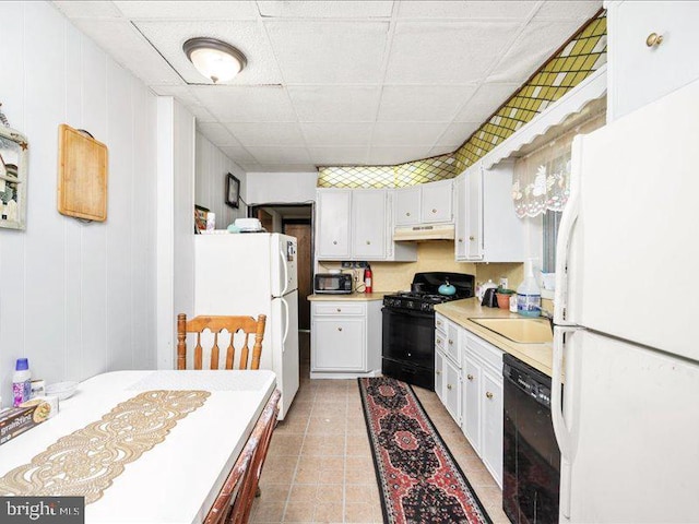 kitchen featuring white cabinetry, sink, a drop ceiling, and black appliances