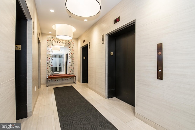 corridor featuring elevator and light tile patterned flooring