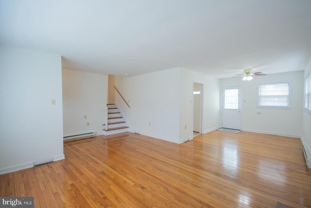 interior space with baseboard heating, light hardwood / wood-style flooring, and ceiling fan