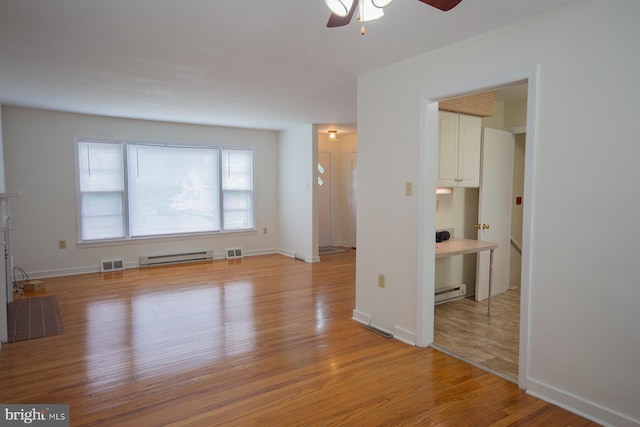 unfurnished living room featuring a baseboard heating unit, ceiling fan, and light hardwood / wood-style flooring