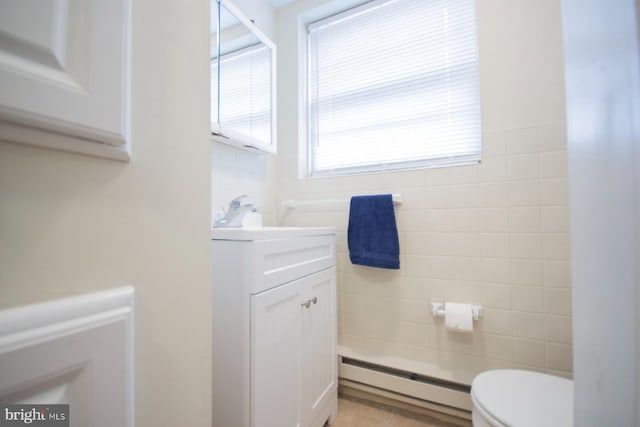 bathroom featuring tile patterned flooring, vanity, baseboard heating, and toilet