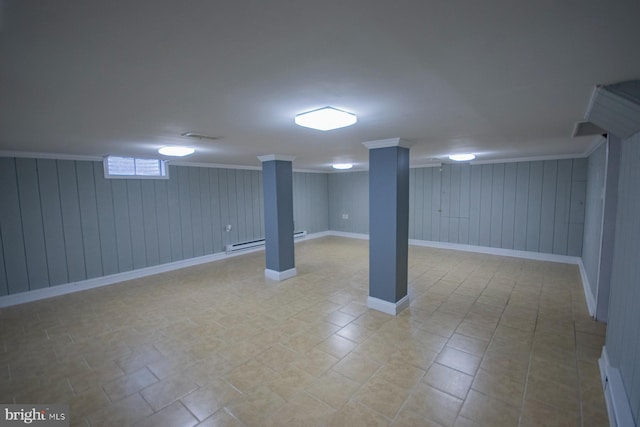 basement with crown molding, wood walls, and a baseboard radiator