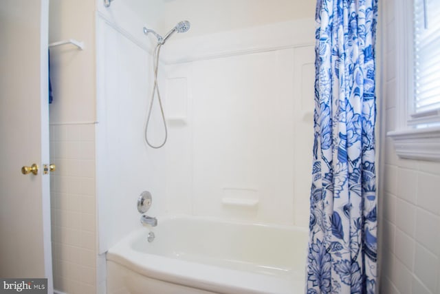 bathroom featuring tile walls and shower / tub combo with curtain