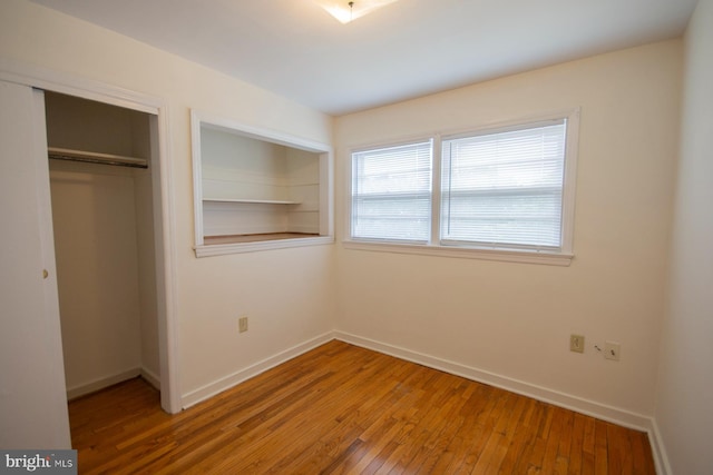 unfurnished bedroom with a closet and hardwood / wood-style floors