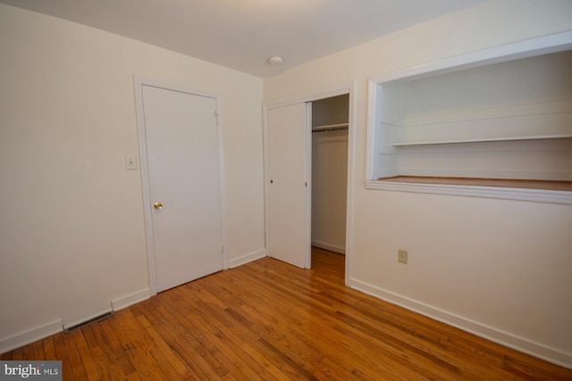 unfurnished bedroom featuring a closet and wood-type flooring