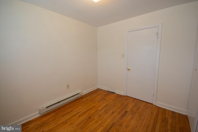 spare room featuring hardwood / wood-style flooring and a baseboard radiator