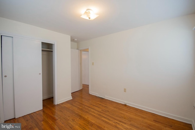 unfurnished bedroom with a closet and wood-type flooring