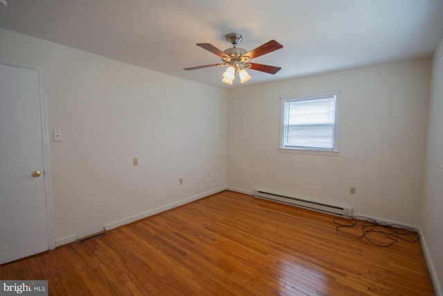 empty room featuring a baseboard heating unit, ceiling fan, and wood-type flooring